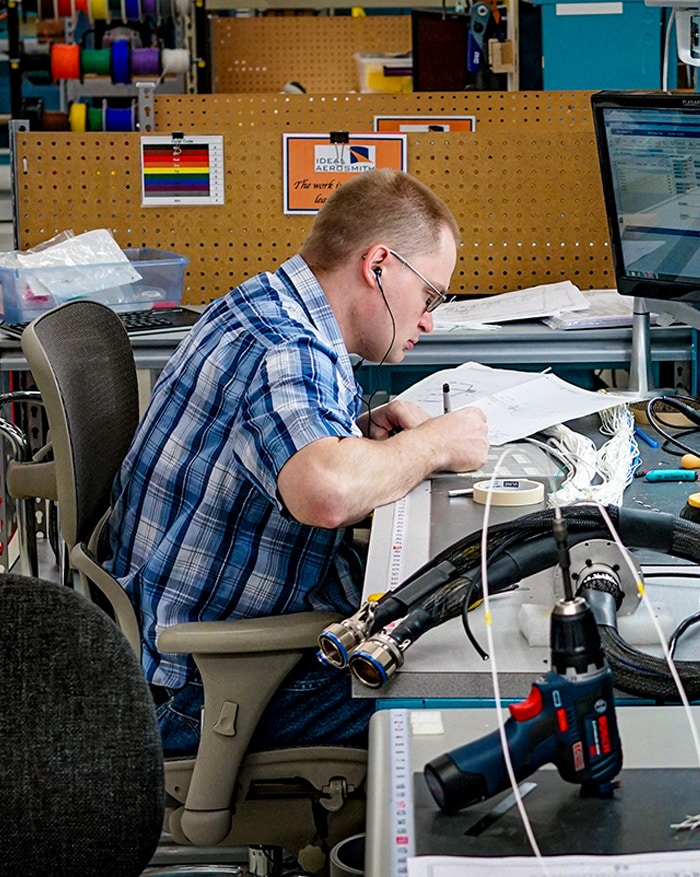 Start your career here! Here is an Ideal Aerosmith Employee working at a desk.